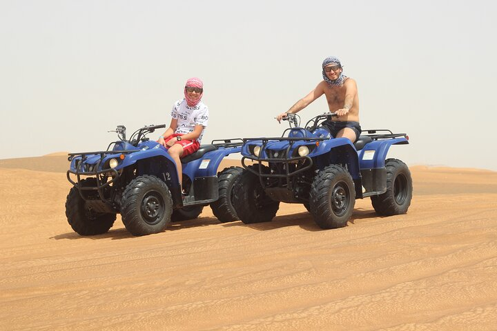 Experience the vast beauty of the Arabian Desert as you ride Yamaha 350cc quad bikes carving through silky red sands and enjoying the freedom of adventure.